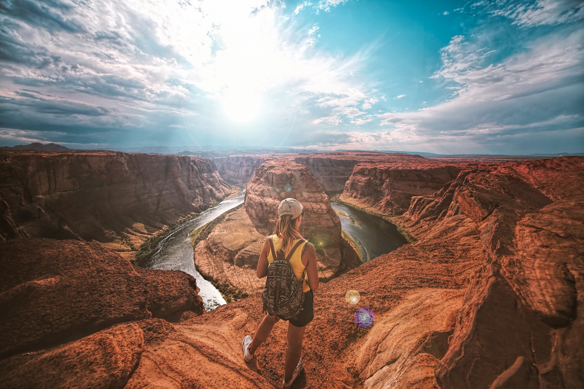 Hiker overlooking a river winding through a desert canyon