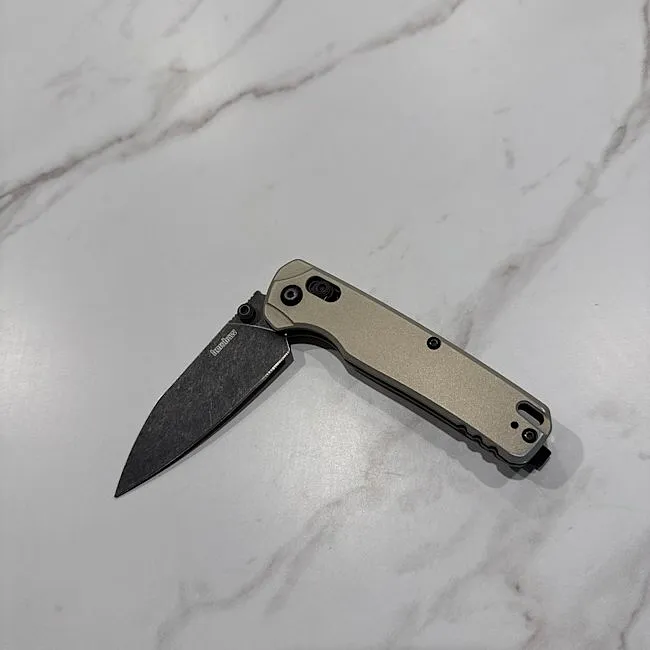 Kershaw Bel Air folding knife open on a pale stone surface