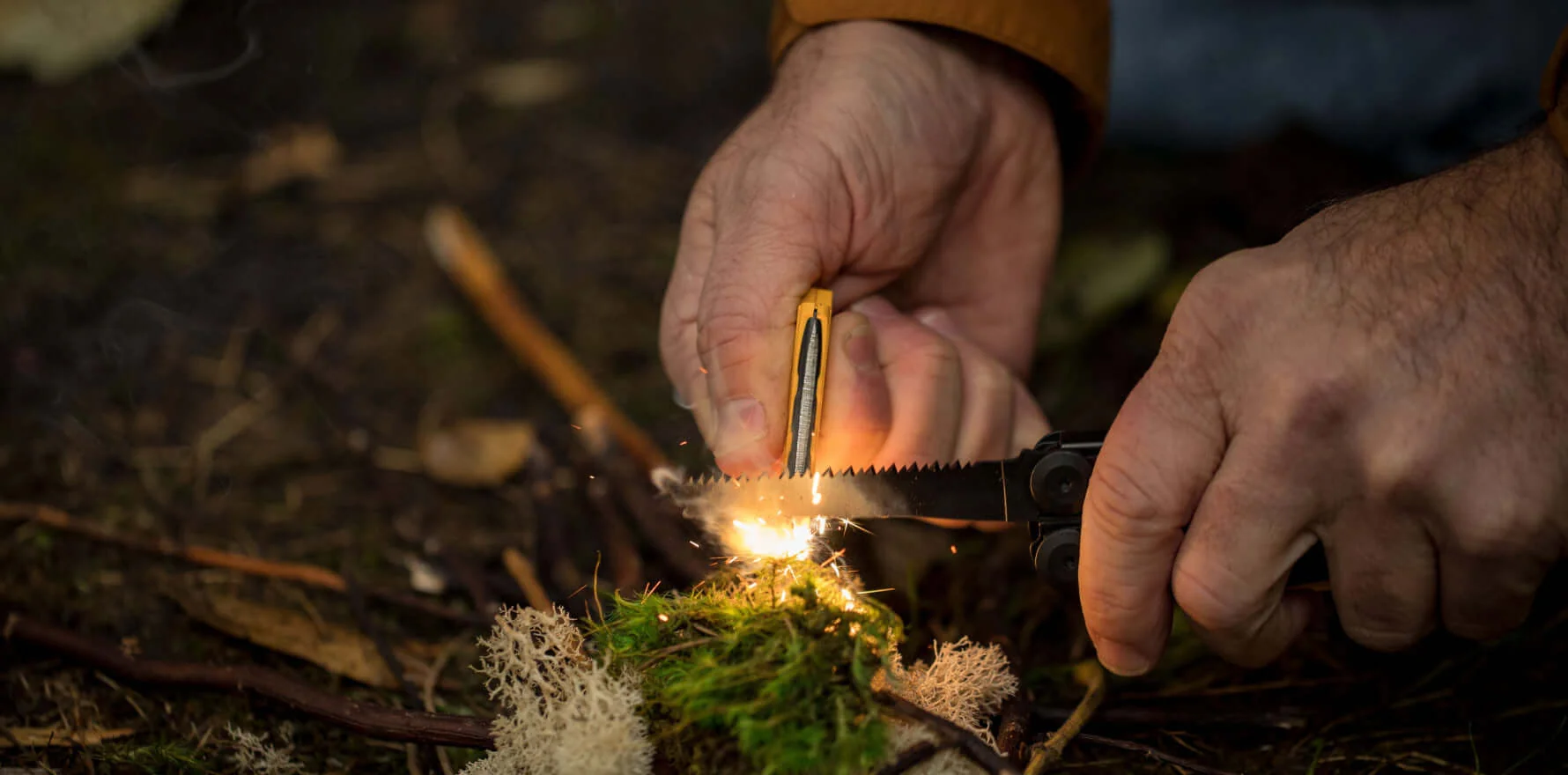 Leatherman Signal ferrocerium rod throwing sparks into campfire tinder
